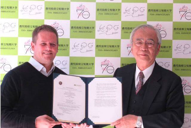 協定書を手にするBryan氏と野呂学長(当時)